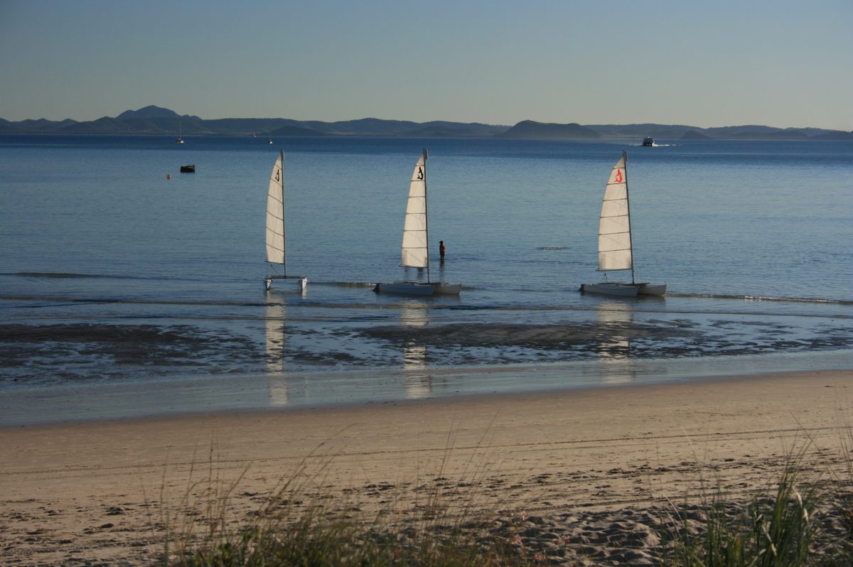 Catamarans pulled up on a quiet beach