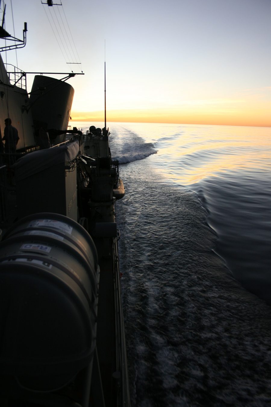A ship’s wake at sunset, seen from the deck